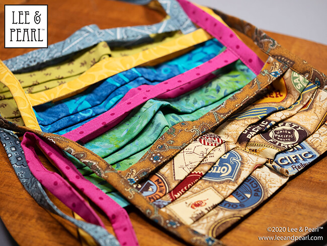 Handmade batik fabric face masks are now available in the Lee & Pearl Etsy store. We make these masks ourselves using our own pattern, which features fabric ties, nose wire pockets, stacked top pleats, chin darts for a better fit, and the innovative NO GAP STRAP — a separate strap, cut slightly shorter than the mask to maintain tension across the top of the mask, while allowing the fabric underneath to conform to the shape of your nose.