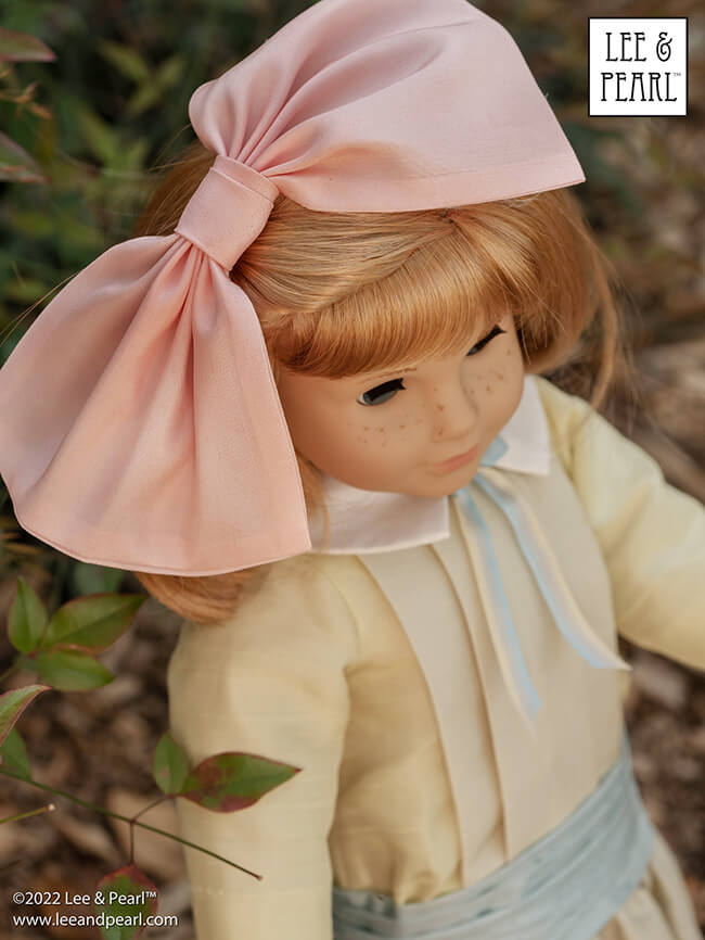 Happy Easter from Lee & Pearl! In this holiday pictorial, join our American Girl® doll Nellie as she explores a hidden garden, dressed in a lovely silk dress embellished with ribbons and bows, accompanied by seasonal props from our FREE tutorial and printable collection and the craft store floral and spring decor aisles.