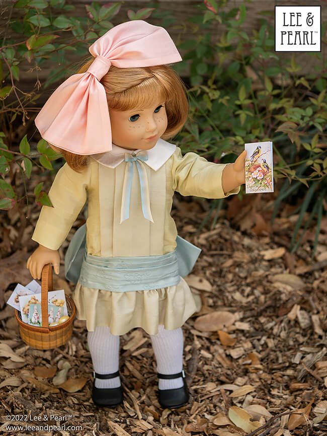 Happy Easter from Lee & Pearl! In this holiday pictorial, join our American Girl® doll Nellie as she explores a hidden garden, dressed in a lovely silk dress embellished with ribbons and bows, accompanied by seasonal props from our FREE tutorial and printable collection and the craft store floral and spring decor aisles.